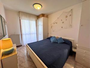 a bedroom with a blue bed and a window at Magnolia in Grado