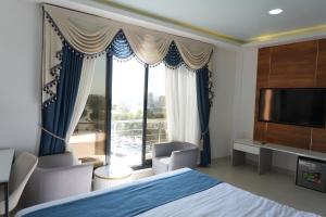 a hotel room with a bed and a large window at Gulf Star Hotel Hargeisa in Hargeysa