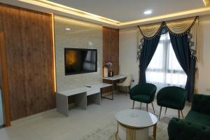 a living room with a couch and a tv on a wall at Gulf Star Hotel Hargeisa in Hargeysa +19 photos