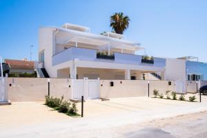 a white house with a fence at Residence Casuzze in Marina di Ragusa