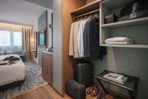 a hotel room with a bed and a closet at Le Méridien Paris Arc De Triomphe in Paris +153 photos