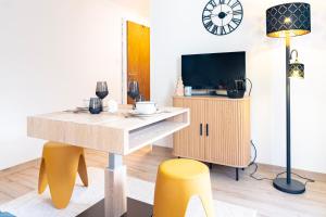 a living room with a table and yellow stools at Superbe Studio Morgins au Pied des Pistes avec Piscine in Morgins