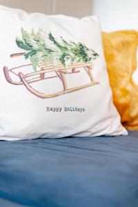 a pillow with ahappy holidays written on it on a bed at Superbe Studio Morgins au Pied des Pistes avec Piscine in Morgins +7 photos