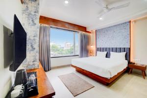 a bedroom with a bed and a large window at Palette by CheckIn Patel Nagar Bhopal in Bhopal