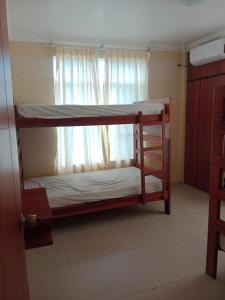 a bunk bed in a room with a window at Departamentos Dentro de CABAPLAN CONJUNTO CON SEGURIDAD in Tonsupa