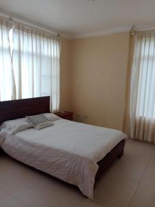 a bedroom with a large bed with white sheets at Departamentos Dentro de CABAPLAN CONJUNTO CON SEGURIDAD in Tonsupa