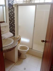 a bathroom with a toilet and a sink and a shower at Departamentos Dentro de CABAPLAN CONJUNTO CON SEGURIDAD in Tonsupa
