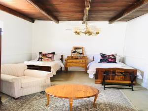 a living room with two beds and a coffee table at Klaarstroom Hotel in Klaarstroom