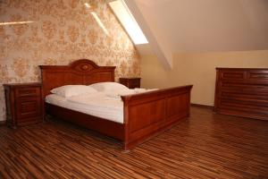 a bedroom with a wooden bed and two dressers at Apartment Kotva in Bratislava