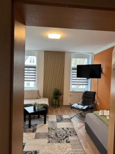 a living room with a bed and a tv at Ferienwohnung Florion 4 in Bernburg