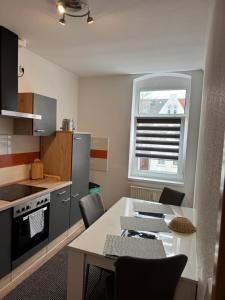 a kitchen with a table with chairs and a window at Ferienwohnung Florion 4 in Bernburg