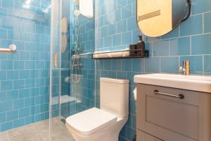 a blue tiled bathroom with a toilet and a sink at Social Lodge Hollywood Studios in Funchal +30 photos