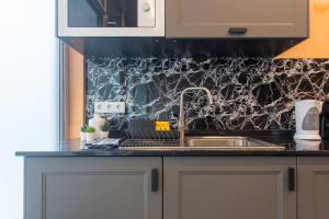 a kitchen with a sink and a laptop on a counter at Social Lodge Hollywood Studios in Funchal