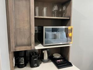 a microwave oven sitting on a shelf in a kitchen at Hidden Haven II - Large Studio Near Beach in Turtle Cove