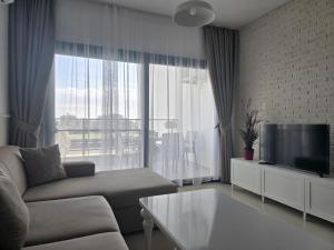 a living room with a couch and a tv at Caesar Resort & Spa Luxury Apartments in Iskele