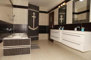 a bathroom with a tub and a sink and a bath tub at Apartment Kotva in Bratislava +14 photos