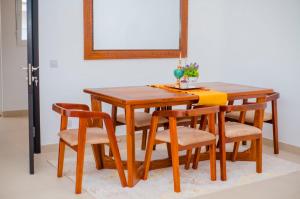 a wooden dining room table with chairs and a mirror at Coastal Escape Haven in Mchamba Wima