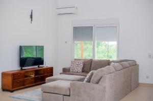 a living room with a couch and a flat screen tv at Coastal Escape Haven in Mchamba Wima