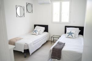 a white room with two beds and a window at Villa Champan in La Ciotat