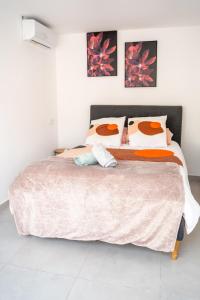 a bedroom with a bed with a pink comforter and pillows at Villa Champan in La Ciotat