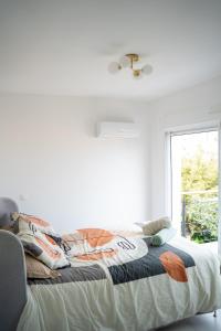 a bed in a white room with a window at Villa Champan in La Ciotat