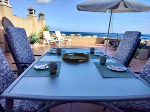 a blue table with chairs and an umbrella on a patio at Anitas Seaview Paradise in La Línea de la Concepción