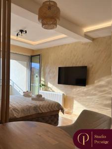 a bedroom with a bed and a flat screen tv at PRESTIGE studio Krusevac in Kruševac