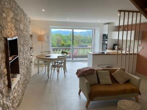 a living room with a couch and a table at La Tranquilitude in Ceyzérieu