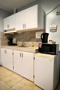 a kitchen with white cabinets and a microwave at Palau Paradise Comfort in Koror