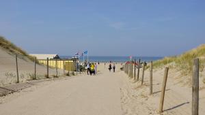 a beach with people walking down a sandy road at BizStay Harbour I Scheveningen Apartments in Scheveningen +8 photos
