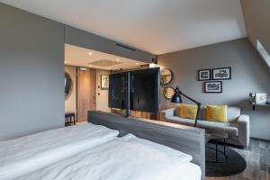 a bedroom with a bed and a couch and a chair at HARBR Hotel Ludwigsburg, a member of Radisson Individuals in Ludwigsburg +106 photos