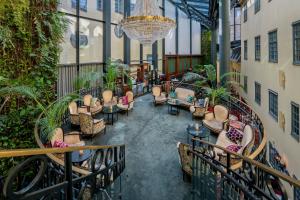 a lobby with chairs and tables and a chandelier at Hotel Kungsträdgården in Stockholm
