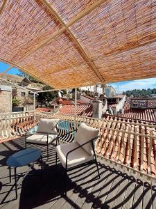 a group of chairs and tables under a pergola at Franka Apartment in Piran