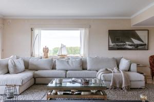 a living room with a white couch and a window at Casiola - Apartment with lake view & common indoor pool in Knokke-Heist