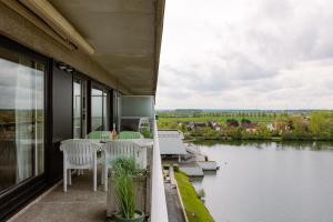 a balcony with a table and chairs and a view of a river at Casiola - Apartment with lake view & common indoor pool in Knokke-Heist