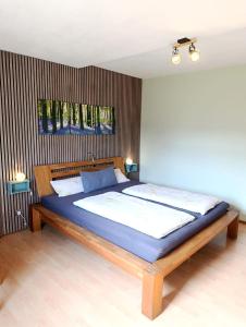 a bedroom with a large bed with blue sheets at FeWO Koeppe in Kopp