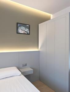 a bedroom with a white bed and a white wall at The Superhost - IL Lux in Crotone