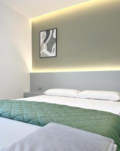 a bedroom with a bed with a green blanket at The Superhost - IL Lux in Crotone