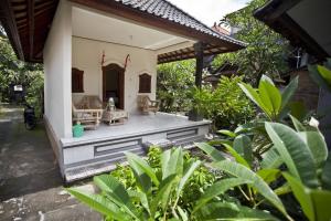 an outdoor patio of a house with plants at Koming House in Ubud