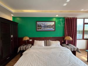 a bedroom with a green wall and a bed at Khách Sạn Nguyễn Hùng in Sapa +9 photos