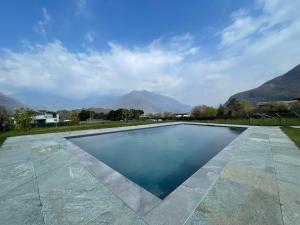 a swimming pool with mountains in the background at Villa Tarca - Colico, Lake Como in Colico
