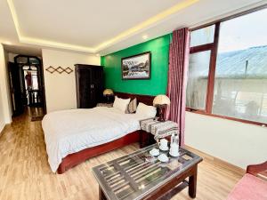 a bedroom with a bed and a green wall at Khách Sạn Nguyễn Hùng in Sapa