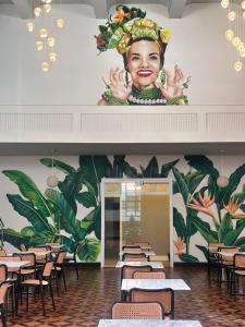 a restaurant with a mural of a woman on the wall at B Hotel 888 hotéis - Próximo a Rodoviária e Praça Sete in Belo Horizonte