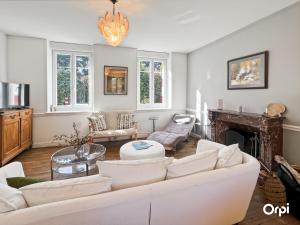 a living room with a white couch and a fireplace at REF 495 Quéven type 7 manor house in Quéven