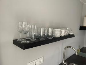 a shelf with wine glasses and bowls on a wall at 't Meuleveld in Harskamp