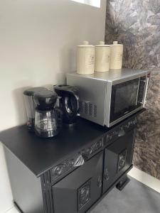 a microwave sitting on top of a black cabinet at 't Meuleveld in Harskamp