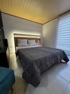 a bedroom with a bed with a black and white blanket at Céntrico apto 202 in Tunja