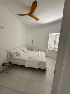 a bedroom with a bed and a ceiling fan at Ancient Wall House in Kampos Paros