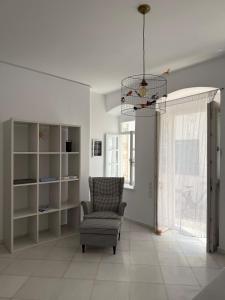a living room with a chair and a window at Ancient Wall House in Kampos Paros