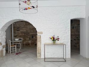 a room with a white brick wall and a table with flowers at Ancient Wall House in Kampos Paros +6 photos